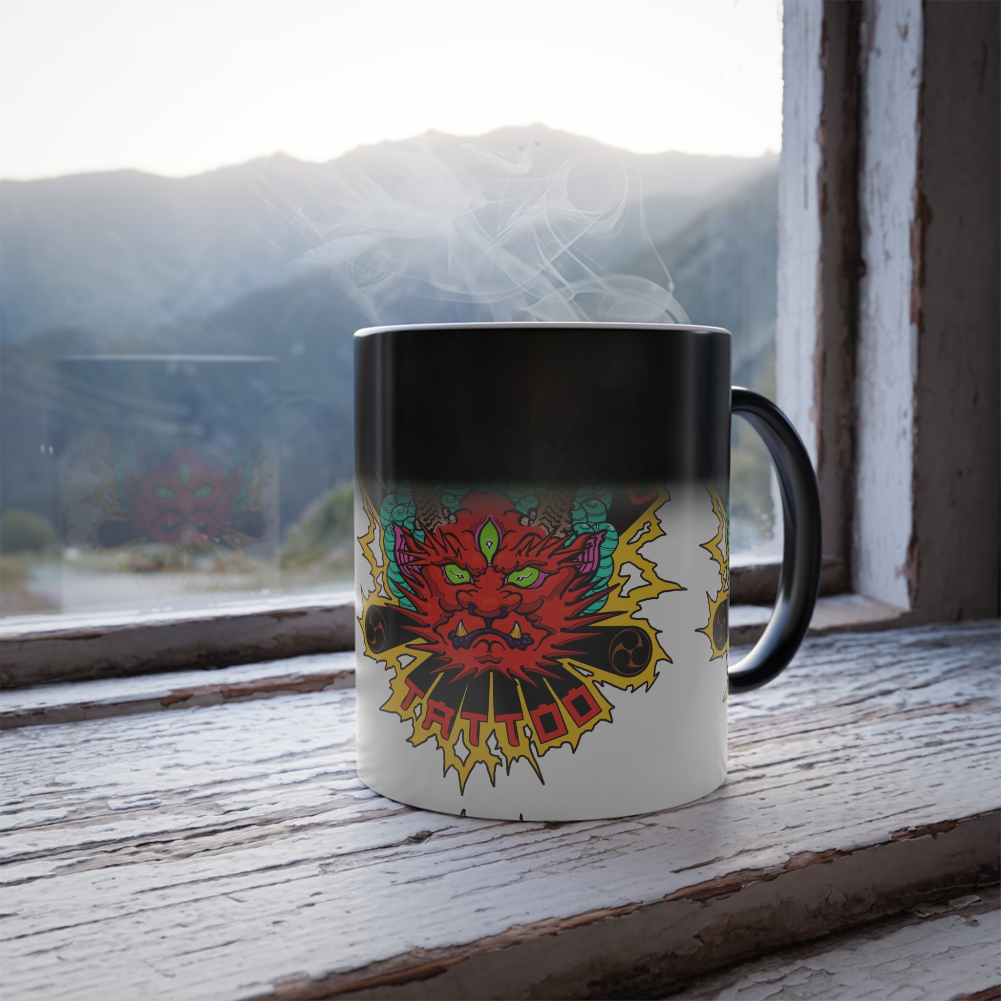 Mug with a colorful dragon design on a windowsill with a mountain view.