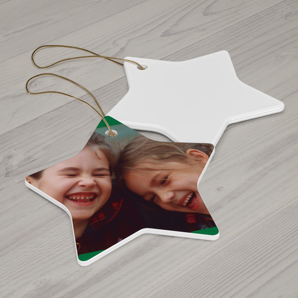 Star-shaped photo ornament with two children's faces on a wooden surface